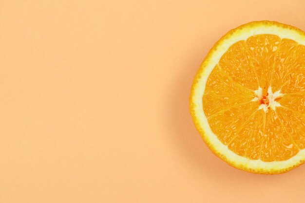 Piece of orange on beige background