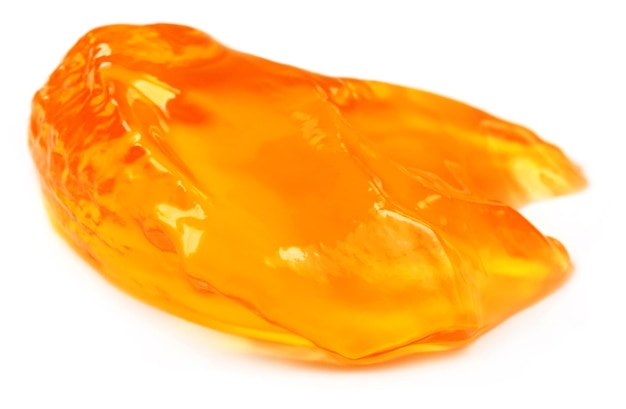 Piece of orange jelly over white background