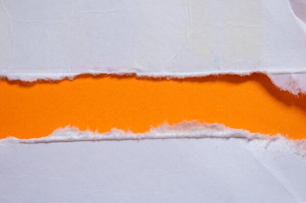 A piece of paper with a torn edge that is orange