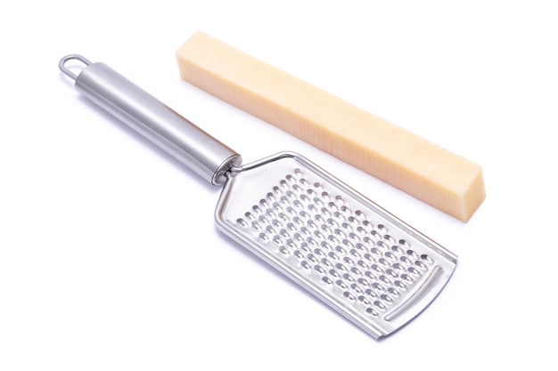 piece of parmesan cheese and grater isolated on white background