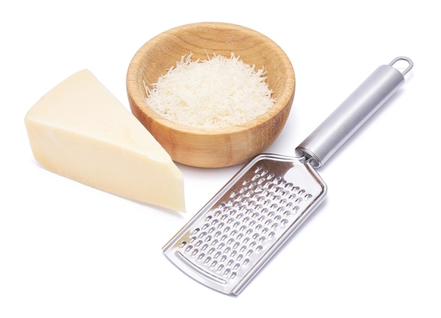 Piece of parmesan cheese knife and grated cheese in wooden bowl isolated on white background