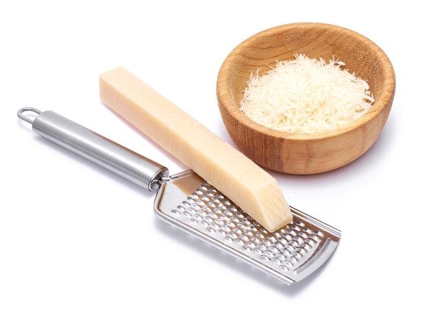 Piece of parmesan cheese knife and grated cheese in wooden bowl isolated on white background