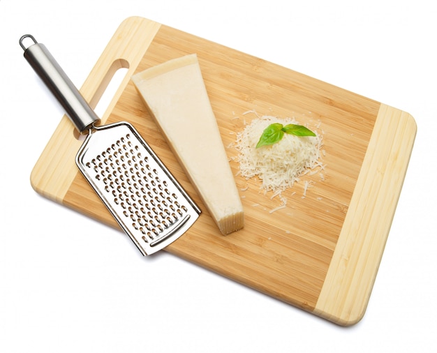 A piece of Parmesan and grated cheese on cutting board