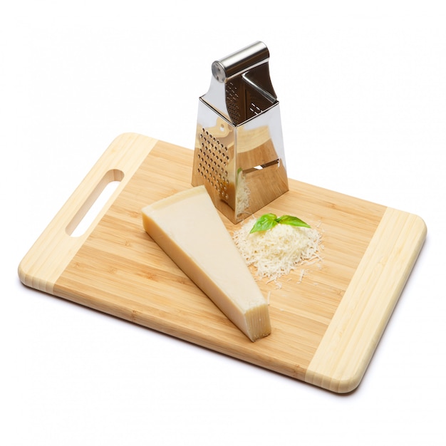 A piece of Parmesan and grated cheese on cutting board