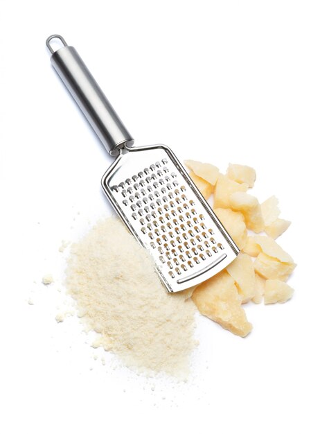 Photo a piece of parmesan and grated cheese on white table