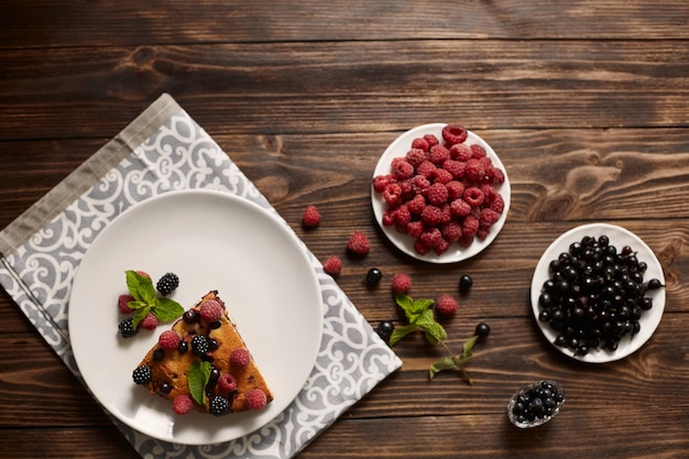 Piece of pie with blueberries, rasberry and mint for dessert