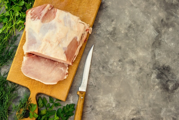 Piece of pig meat on the Board. Cooking. Selective focus.