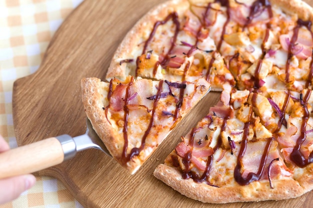 Piece of pizza on a metal spatula woman's hand lays out a pizza