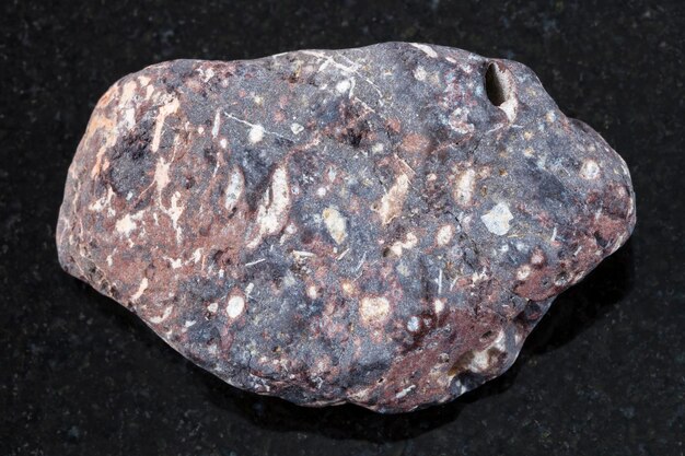 Piece of porous basalt stone on dark background