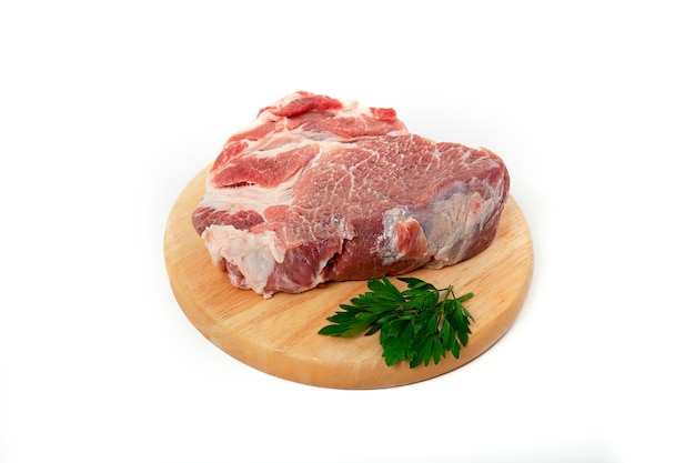 A piece of raw meat pork on a wooden backing