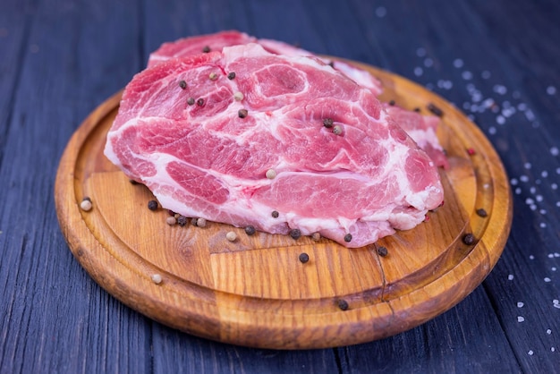 A piece of raw pork meat on a wooden board