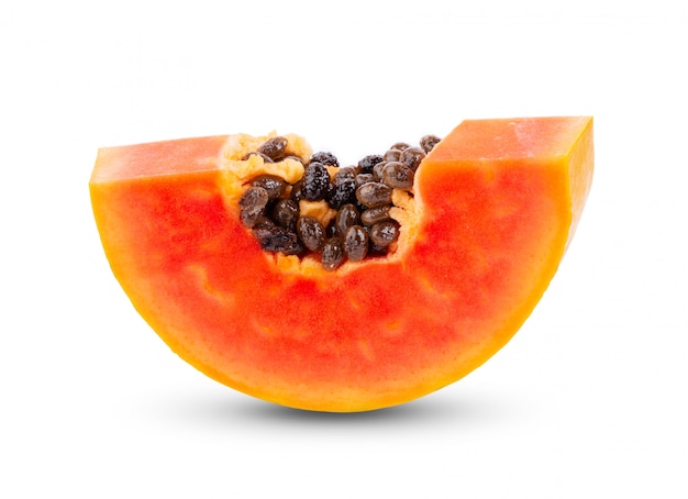 Piece of ripe papaya fruit with seeds on white table