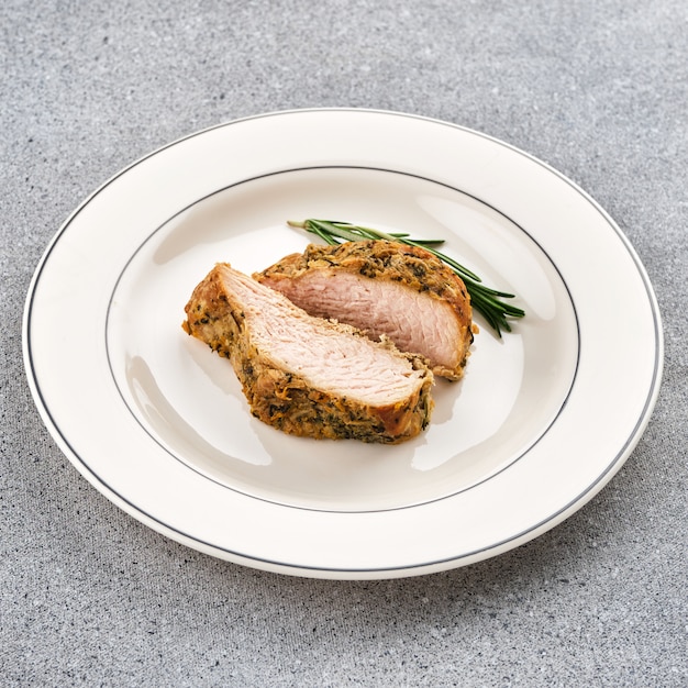 A piece of roast pork with rosemary.