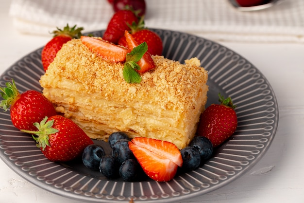 Piece of russian honey cake medovik served with berries