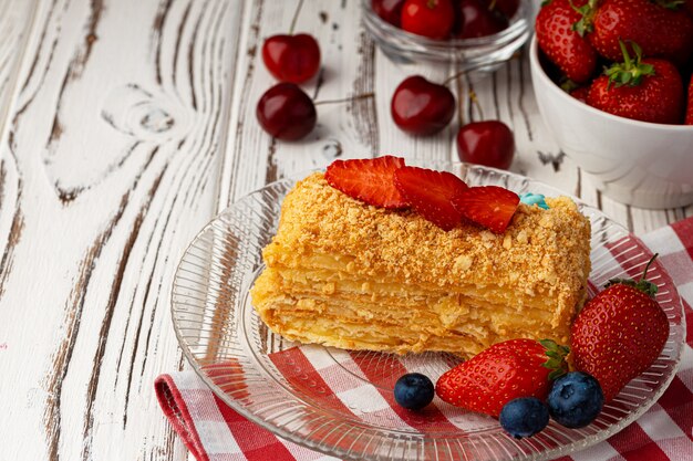 Piece of russian honey cake medovik served with berries