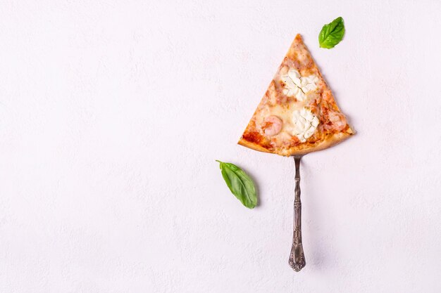 Piece of seafood pizza with shrimps and salmon on white background.