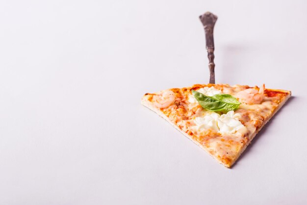 Foto pezzo di pizza ai frutti di mare con gamberi e salmone su sfondo bianco.