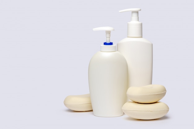 piece of soap and bottle of liquid soap over light grey backgound with clipping path