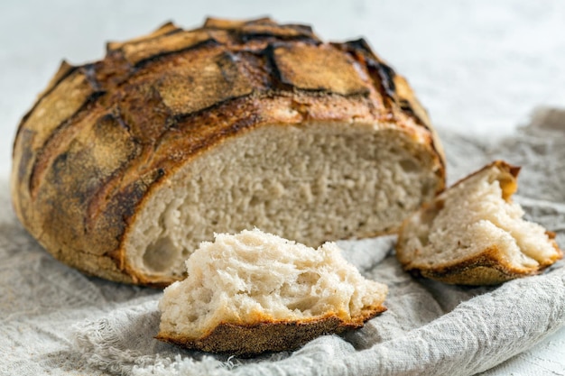 Piece of sourdough bread and a loaf of artisanal bread