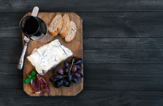 Piece of Spanish Blue cheese on an old wooden cutting board.