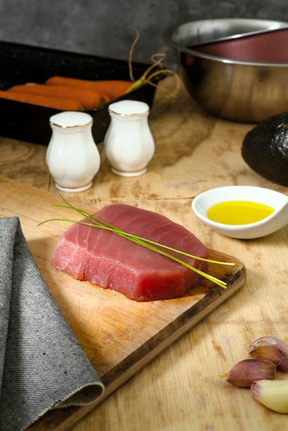 Piece of tuna meat on wooden board with kitchen