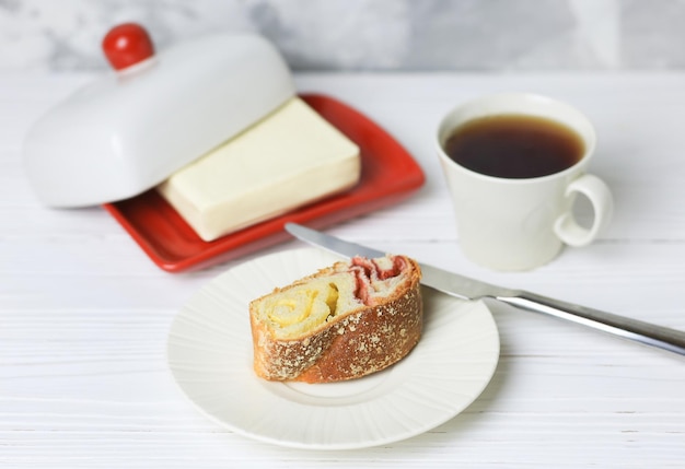 白いテーブルにお茶とオイル缶を入れたチロルのパイ 朝食のコンセプト セレクティブフォーカス