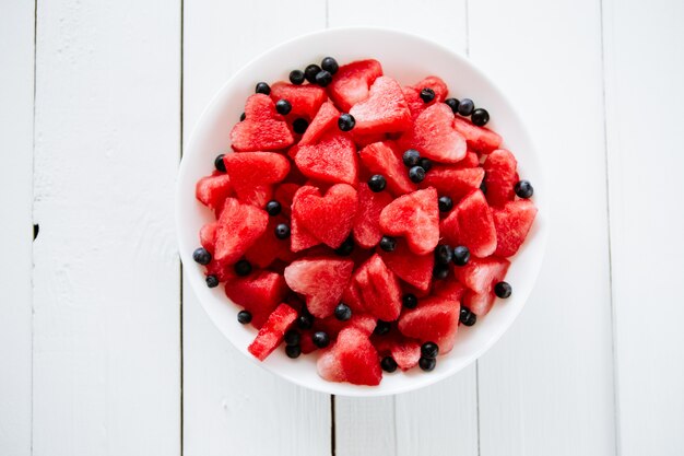 Piece of watermelon and hearts at white background