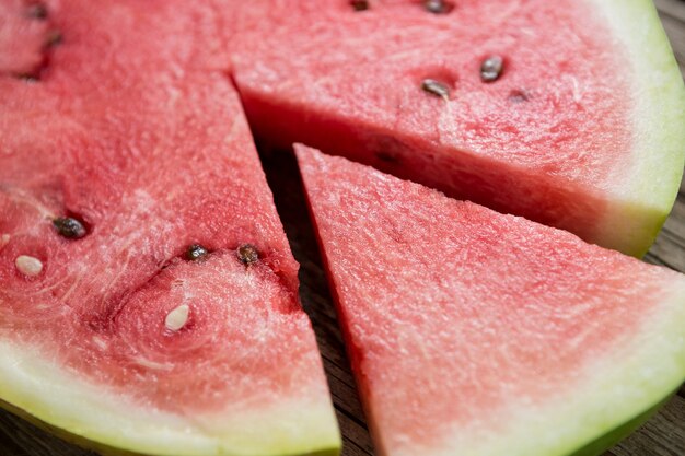 Piece of watermelon separated from slice on wooden table