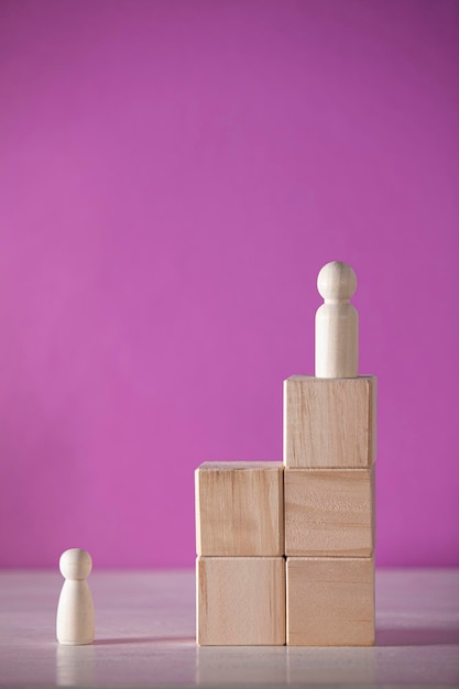 Piece of wood in the shape of a person on a podium and a purple background