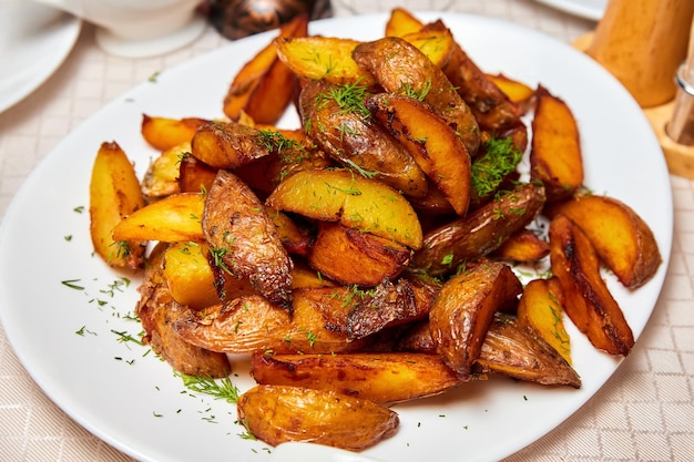 Pieces of baked potatoes on a white plate