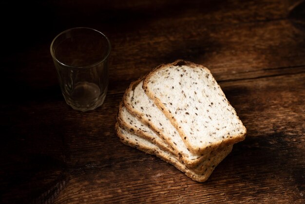 木製の背景に種が付いているパンの断片健康的な健康的なパン健康的な食べ物