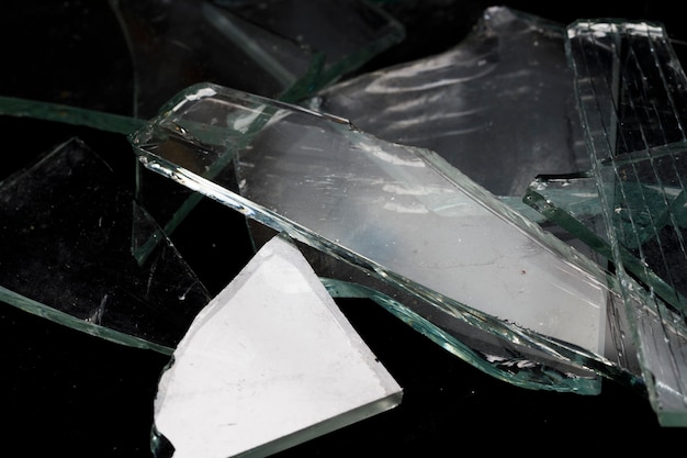 Pieces of broken glass on a black background. High quality photo