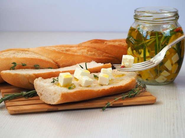 Pieces of cheese marinated in olive oil on a baguette