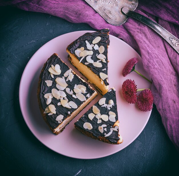 Pieces of cheesecake with chocolate on a pink plate