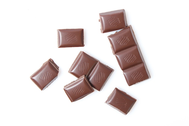 Pezzi di cioccolato isolati sul primo piano bianco