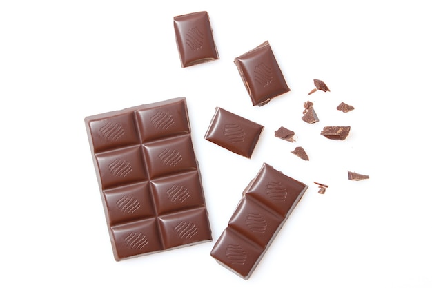 Foto pezzi di cioccolato isolati sul primo piano bianco