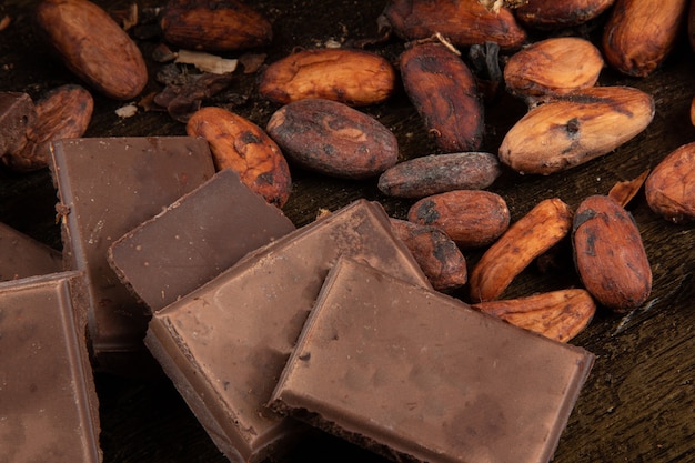 Foto pezzi di cioccolato su fave di cacao crude.