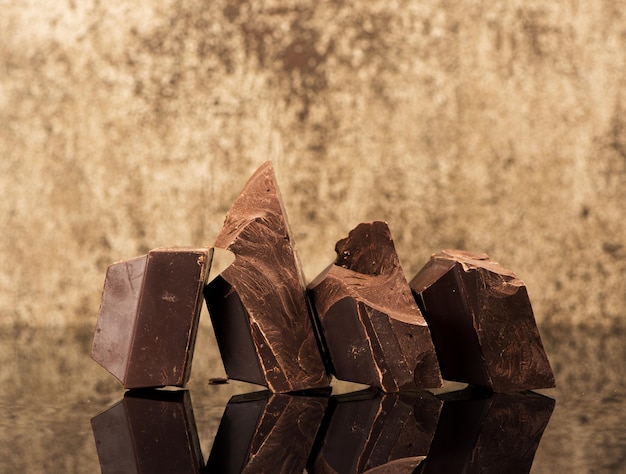 Pieces dark chocolate on a dark stone background