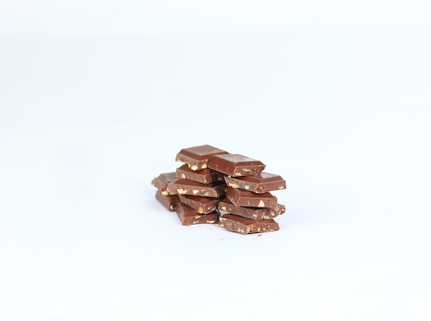 Кусочки темного шоколада с орехами, изолированные на белом фото с копией пространства