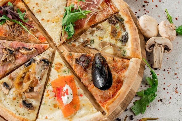 Pieces of different pizza flat lay on concrete background