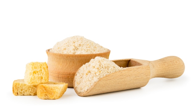 Pieces of dried bread and breadcrumbs in a wooden bowl and spoon