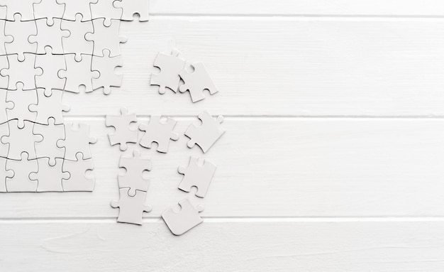 Pieces of empty jigsaw puzzle on white table