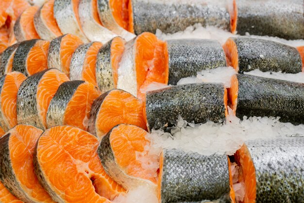 Pieces of fish lie in ice. Fresh salmon steaks  sale in supermarket. Salmon slices on store window. Gourmet Seafood.