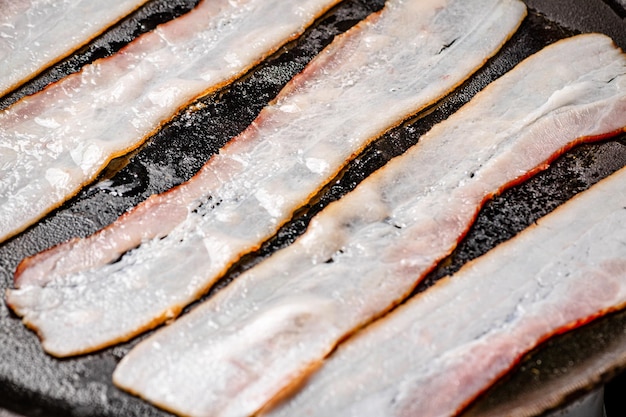 Pieces of fresh bacon on a stone board