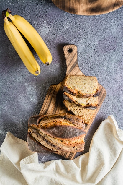 Photo pieces of fresh banana bread on a cutting board social media food top and vertical view