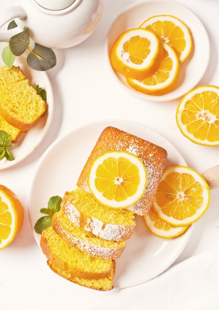 Pieces of fresh homemade baked sliced lemon cake on the white plate.