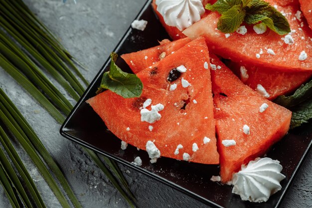 Pieces of fresh red watermelon on a black plate