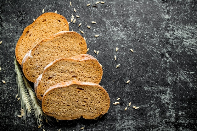 Pieces of fresh rye bread with grains and spikelets