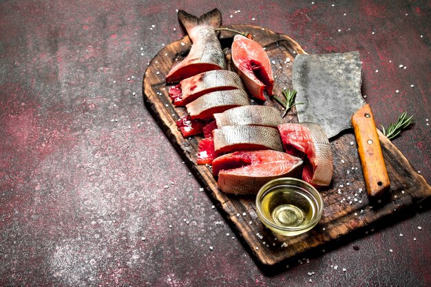 Pieces of fresh trout with spices. On the rustic table.