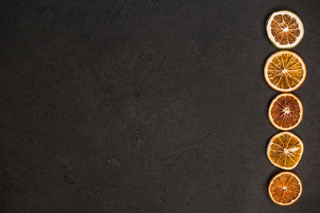 Pieces of fruits arranged in a line on a brown background.